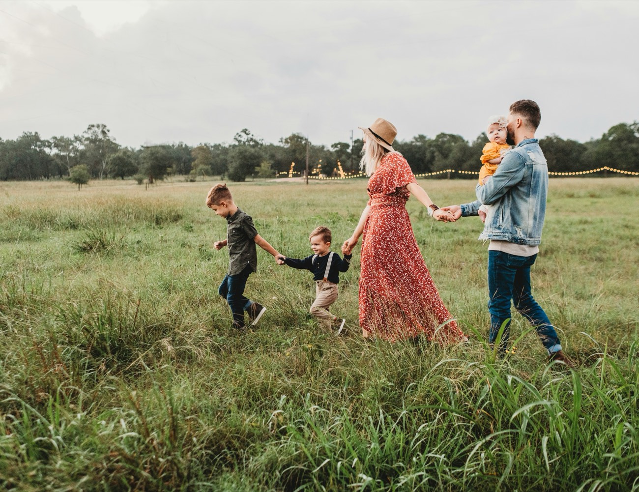 A family walking through a sunlit meadow at golden hour